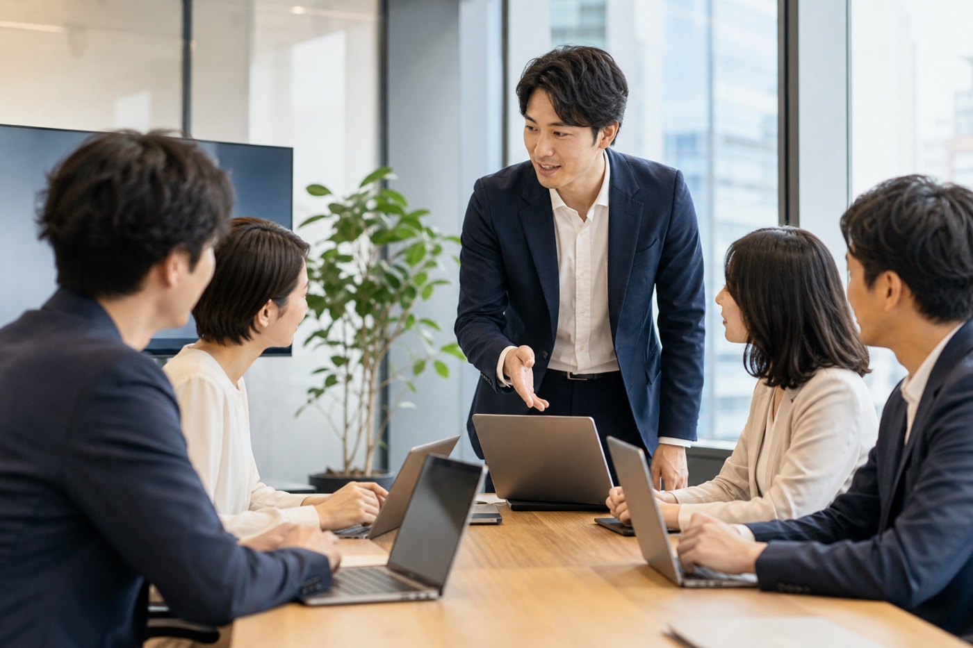 少人数の会議室で、パソコンを開きながら講師と一緒に進める実務AI研修の様子